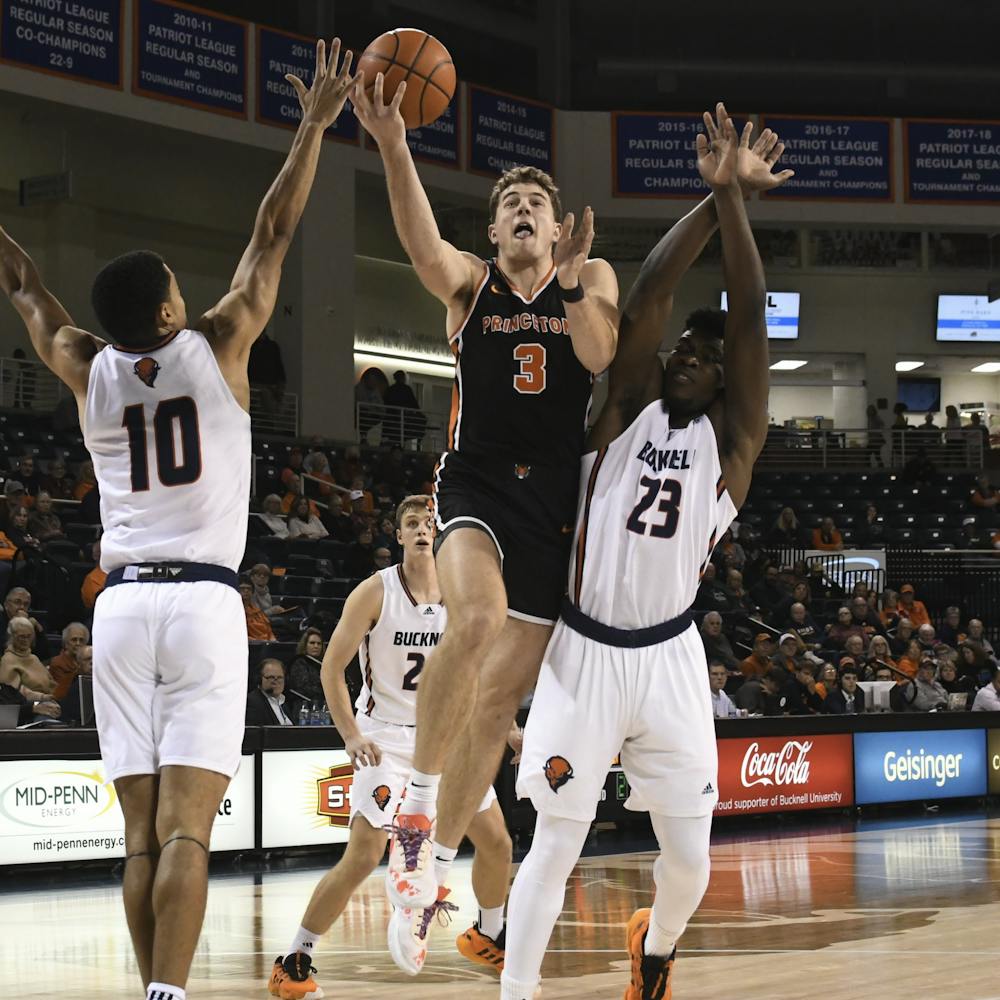 Sophomore forward Caiden Pierce lays the ball up in traffic, surrounded by two Bucknell defenders.
