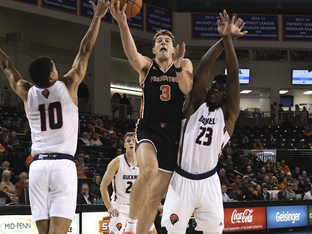 Sophomore forward Caiden Pierce lays the ball up in traffic, surrounded by two Bucknell defenders.