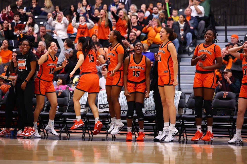 A group of women celebrating on the bench during a basketball game.