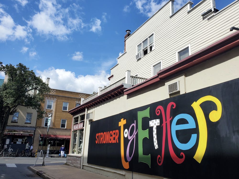A mural with a black background and the words "stronger together" with each letter in a different font and color.
