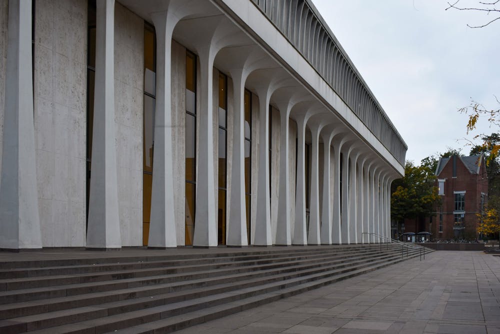 The side of a white building with pillars with steps leading up to it.