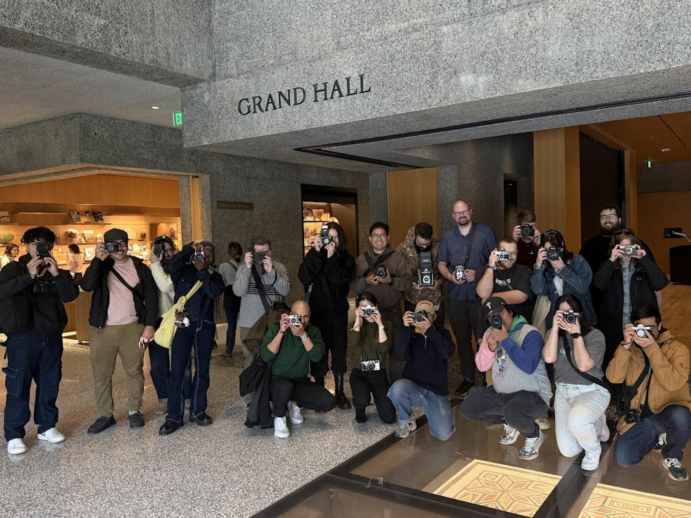 A group of people holding cameras standing in a hall that says "Grand Hall" above.