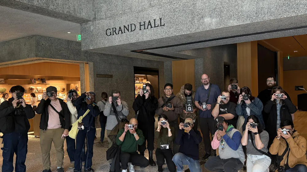 A group of people holding cameras standing in a hall that says "Grand Hall" above.
