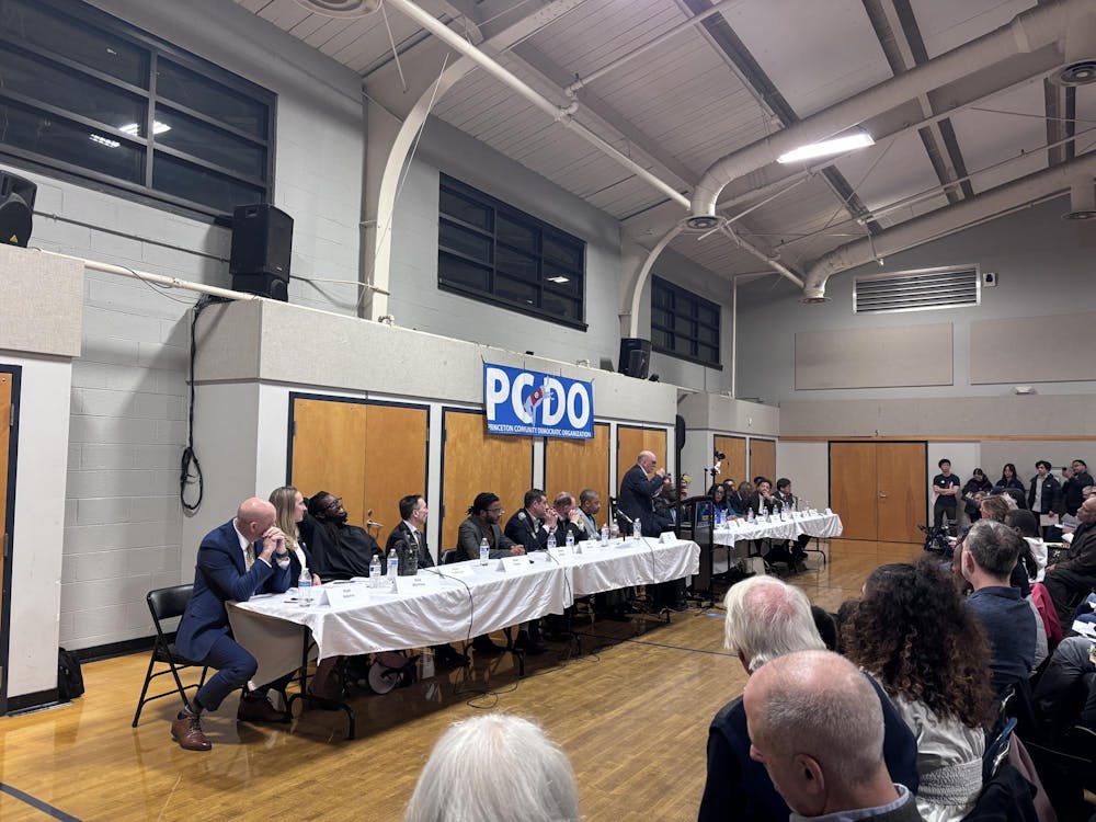 Democratic candidates sitting at a table facing the crowd. 