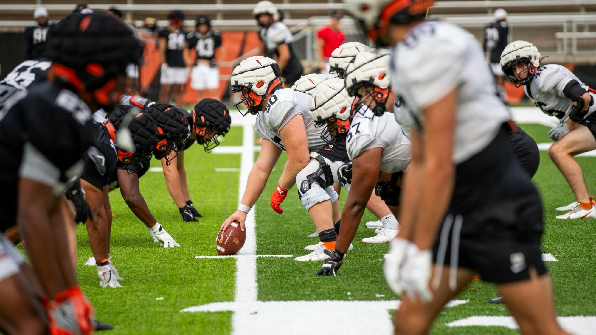 Football players in black and white jerseys line up against each other