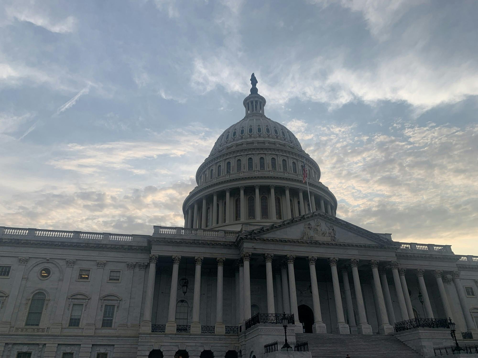 A large building with columns and a domed roof, against the background of a blue sky.
