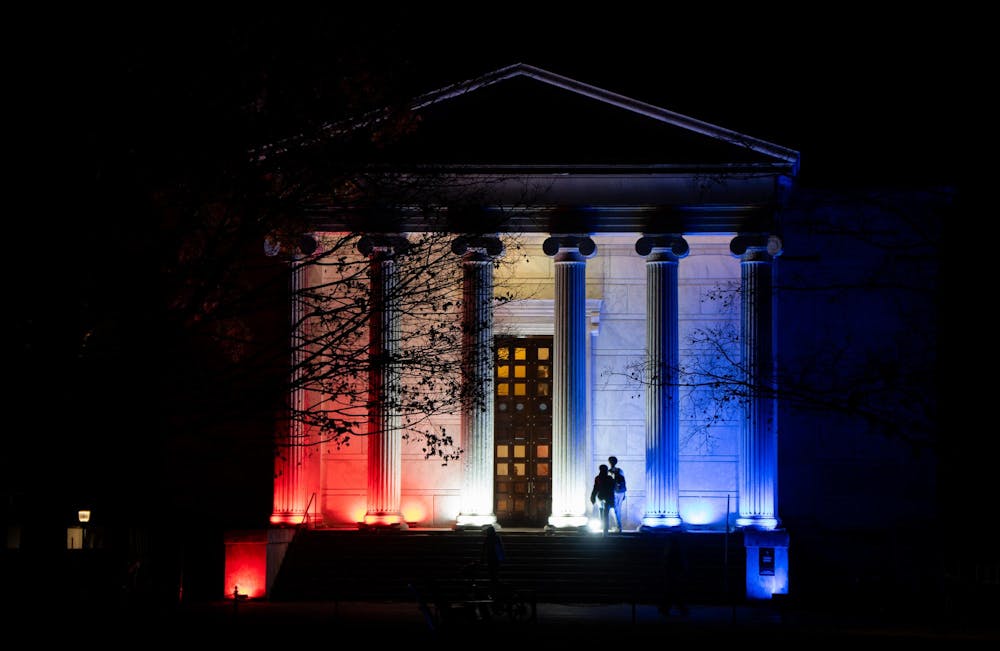 A colonial-style building lit with red, white, and blue lights.