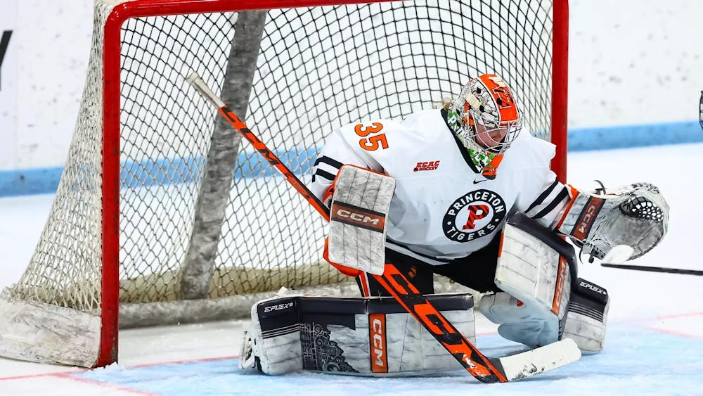 Ice hockey goalie stops puck on her knees.