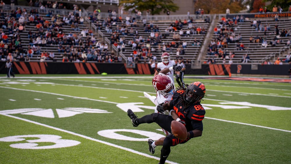 A man crouching in midair is tackled by another man diving directly towards the viewer.