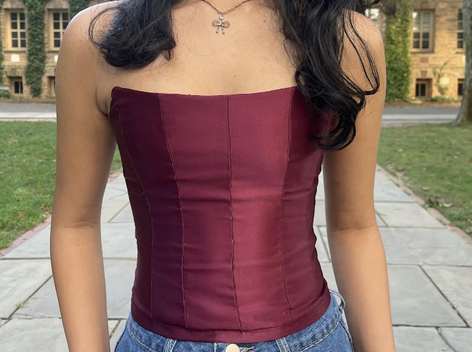 A red corset is against a green grass background.