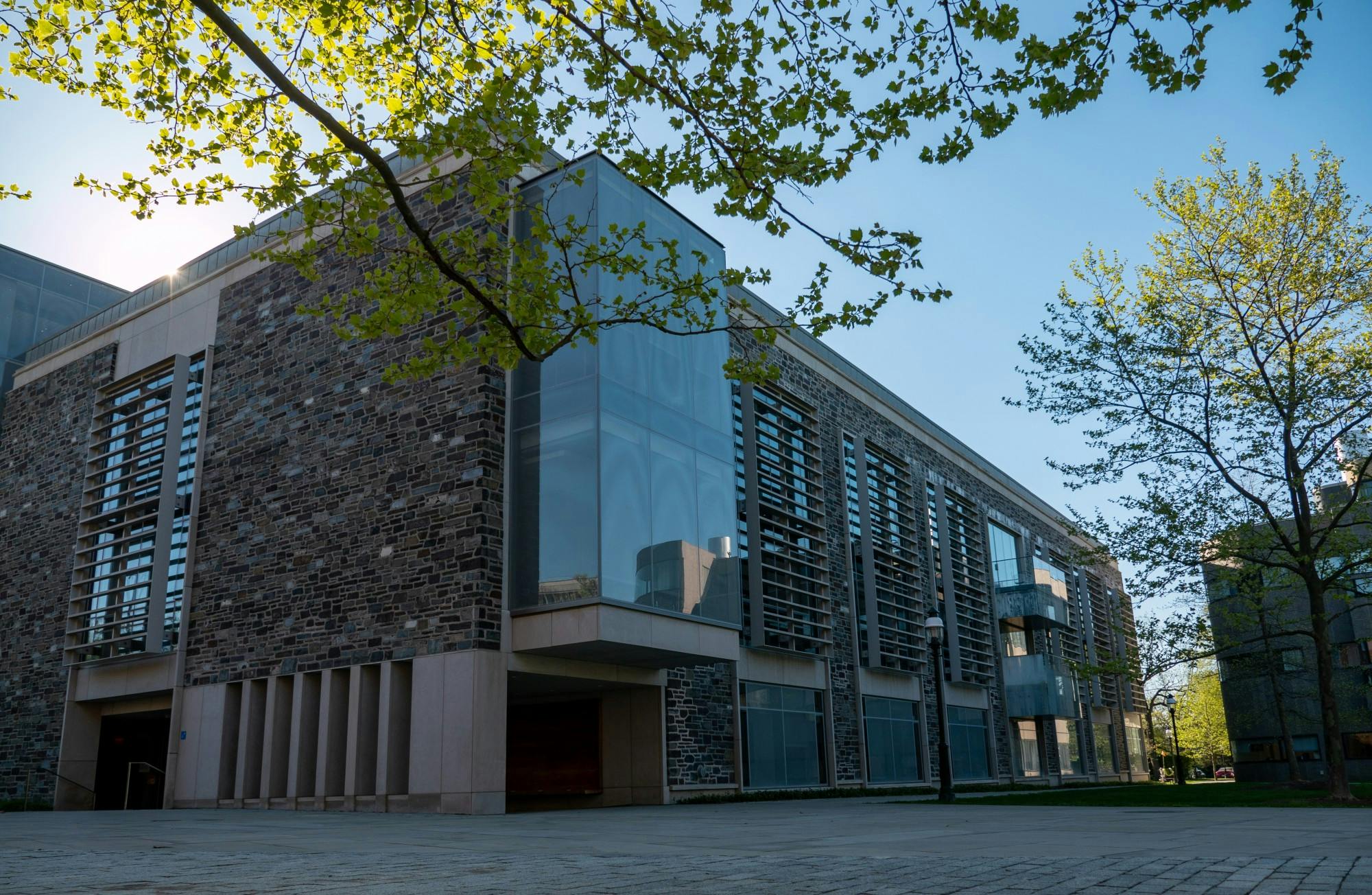 Brick building from a corner angle with large glass windows and a blue sky