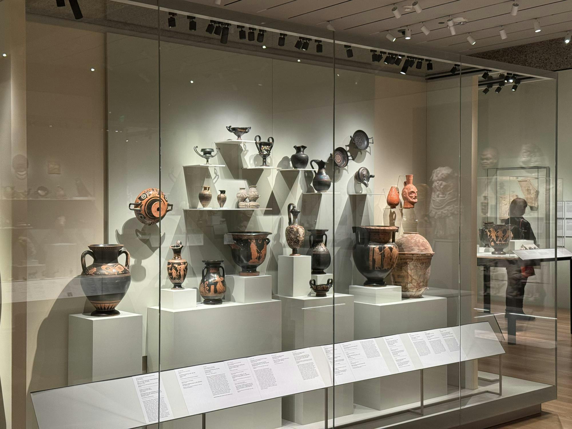 A case of ceramic vases, bowls, and cups.