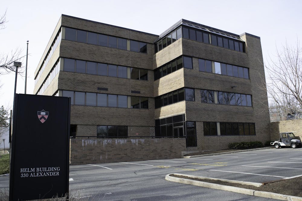 Tan building with windows overlooks a parking lot