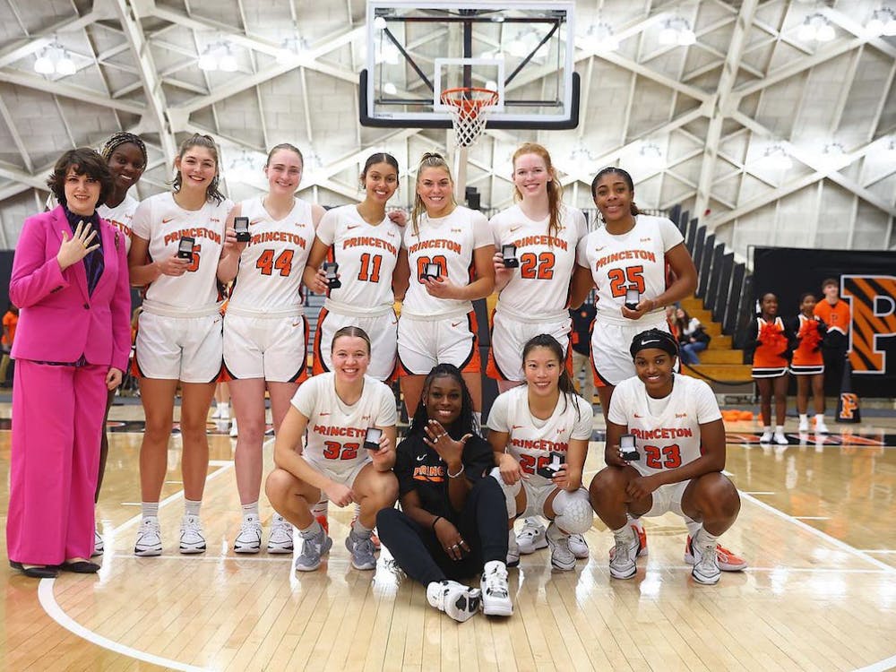 A group of women in white jerseys, each holding a ring on a court.