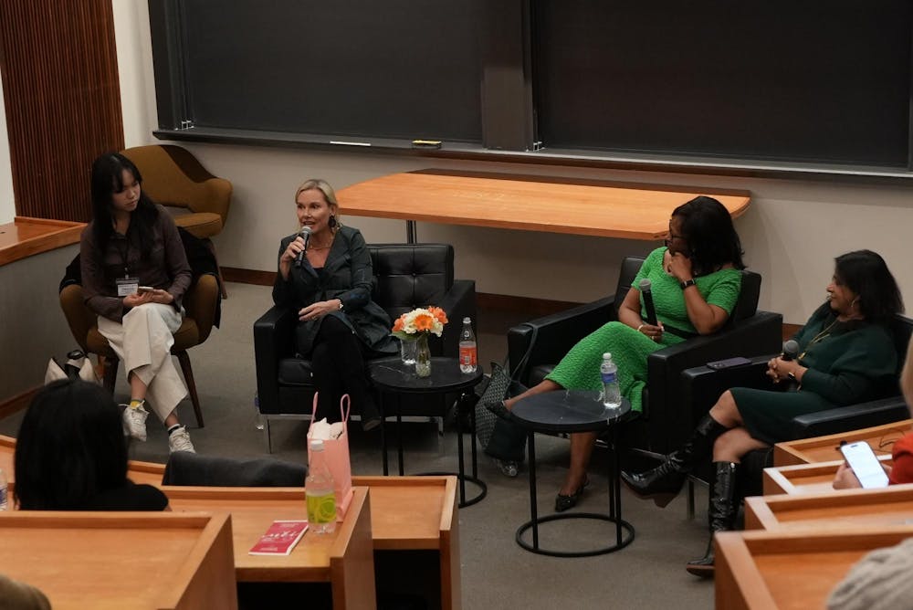 Four women sit in chairs in Robertson Hall. 