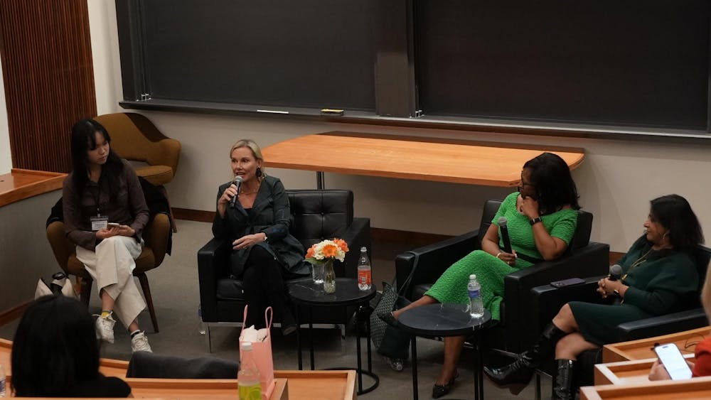 Four women sit in chairs in Robertson Hall.