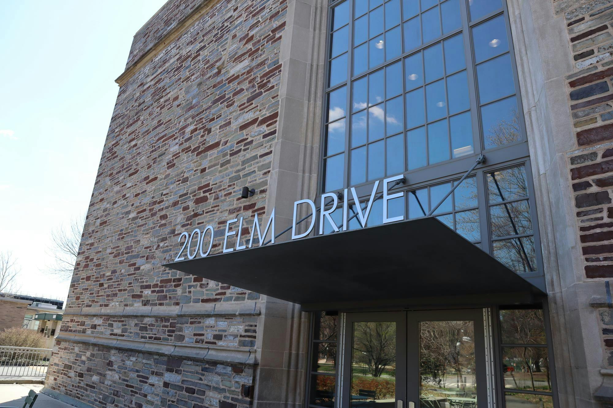 A stone and glass building facade that reads "200 Elm Drive."