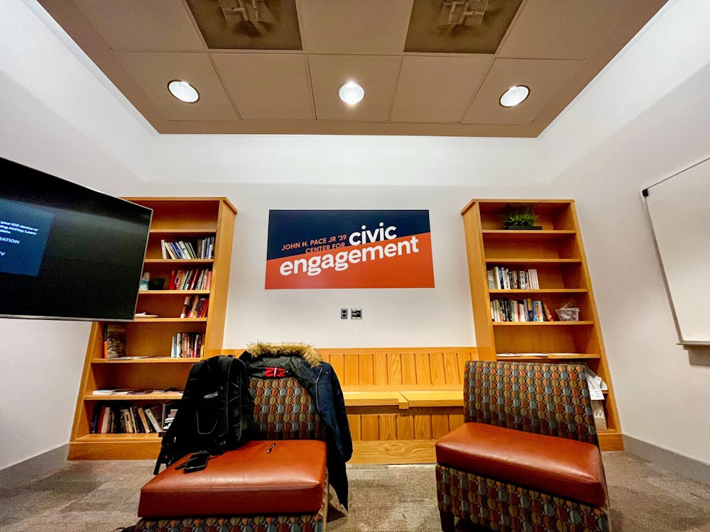 Photo of two orange chairs, with bookshelves and the orange and navy Pace Center for Civic Engagement logo in the background.