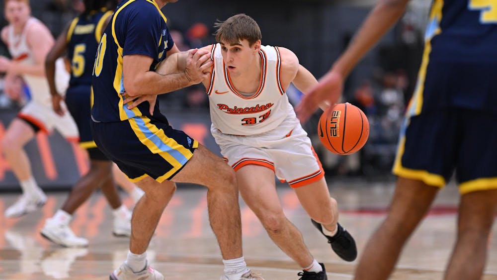 Man in white jersey dribbles a basketball.
