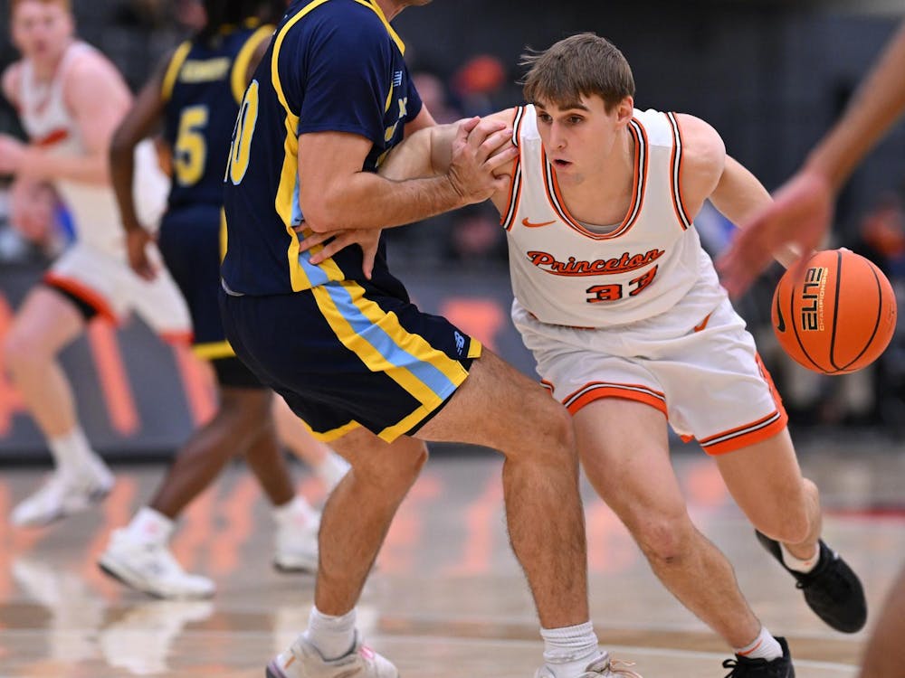 Man in white jersey dribbles a basketball.