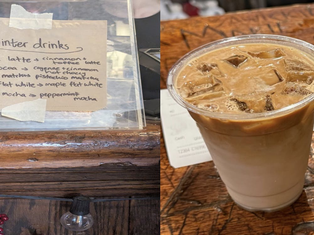 A beige paper-bag is a taped on a glass mirror. It has black sharpie writing on it that lists the winter drinks. The image next to it is a light brown iced latte in a transparent cup on a brown wood table.