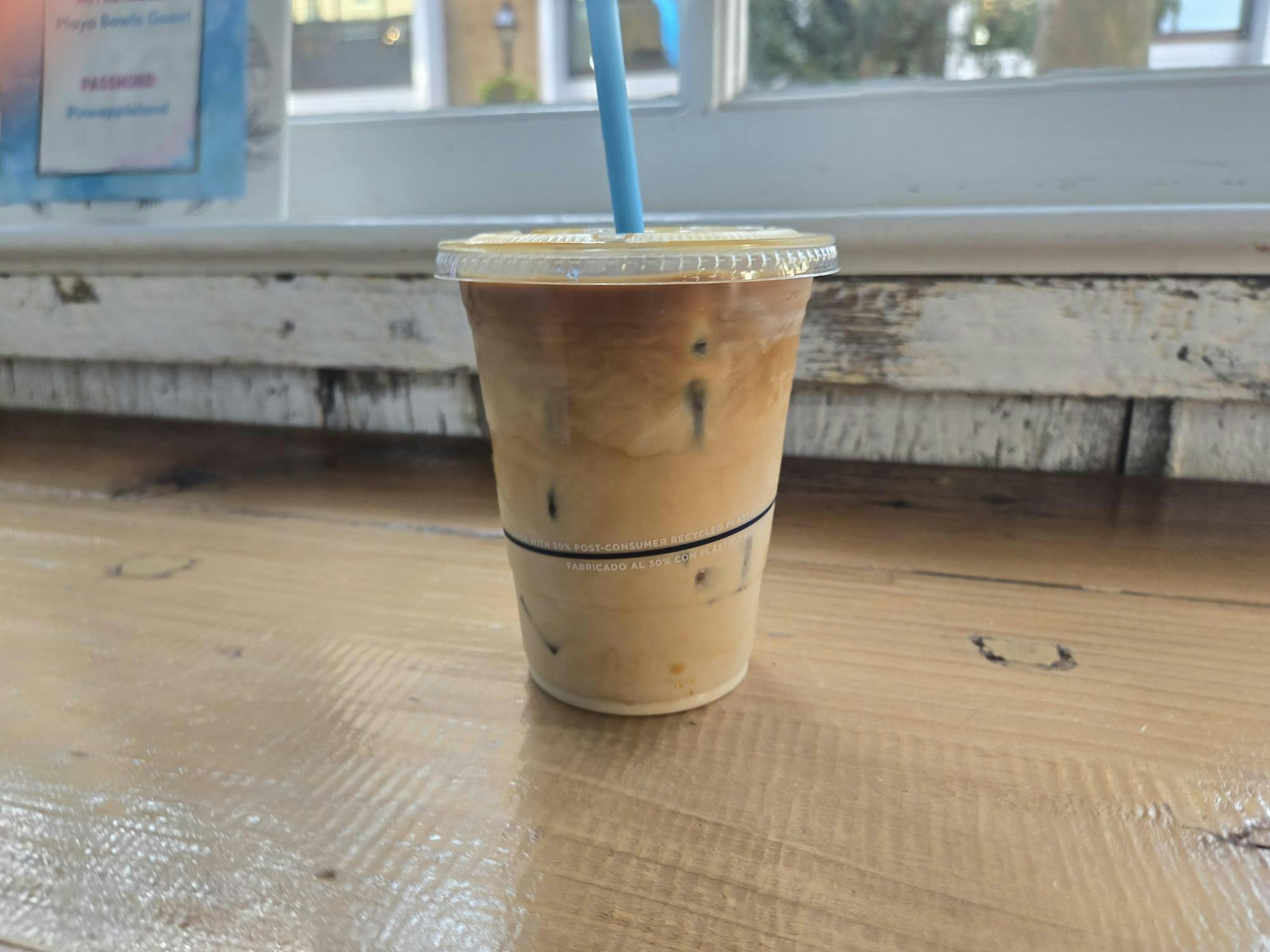 Cup of iced coffee with a straw.