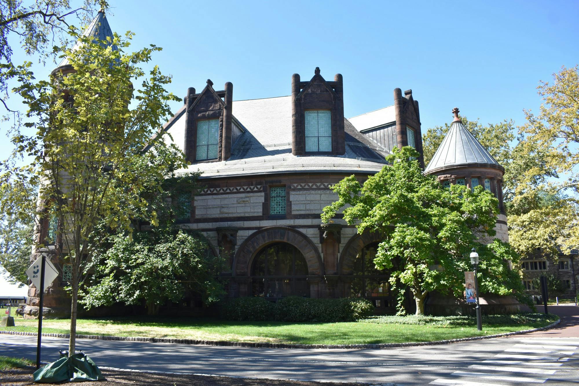 Dark brown and beige university building with gothic architecture on a sunny day. 