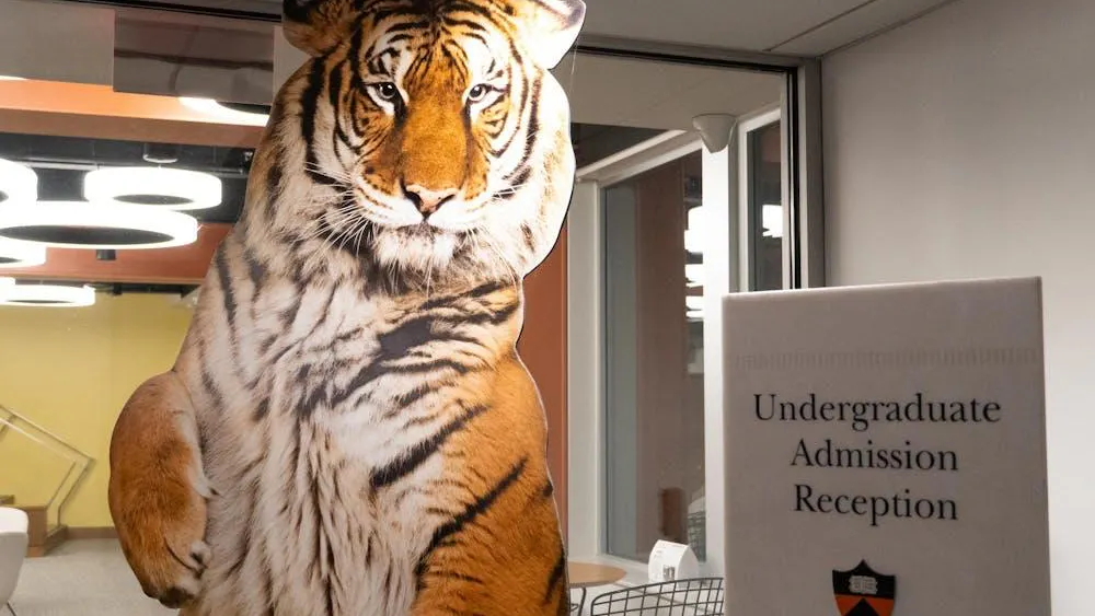 Un cartel de tamaño real de un tigre en una sala con luces circulares y un señal gris.