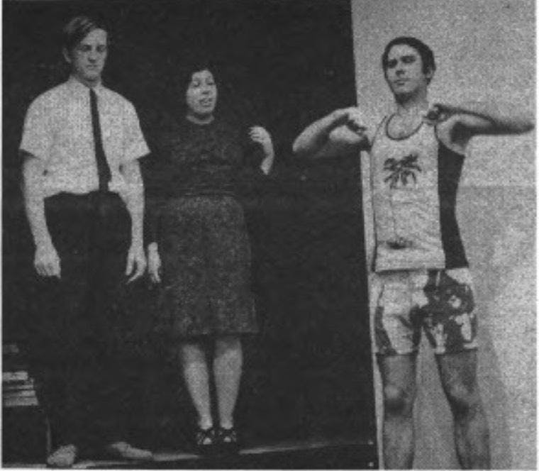 Blurry black and white photo of a young woman standing between two men