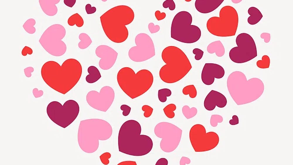 Many red, pink, and purple hearts, assembled in the shape of a larger heart.