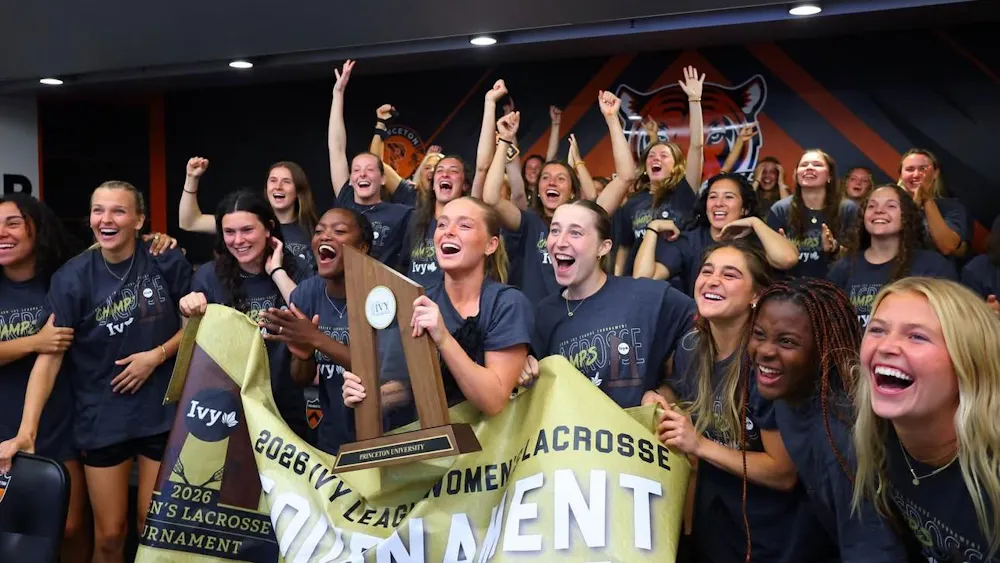 While holding the championship banner and trophy, members of the Princeton women's lacrosse team celebrate after hearing their name called on the NCAA selection show.