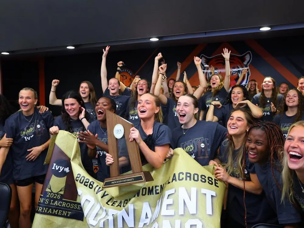 While holding the championship banner and trophy, members of the Princeton women's lacrosse team celebrate after hearing their name called on the NCAA selection show.