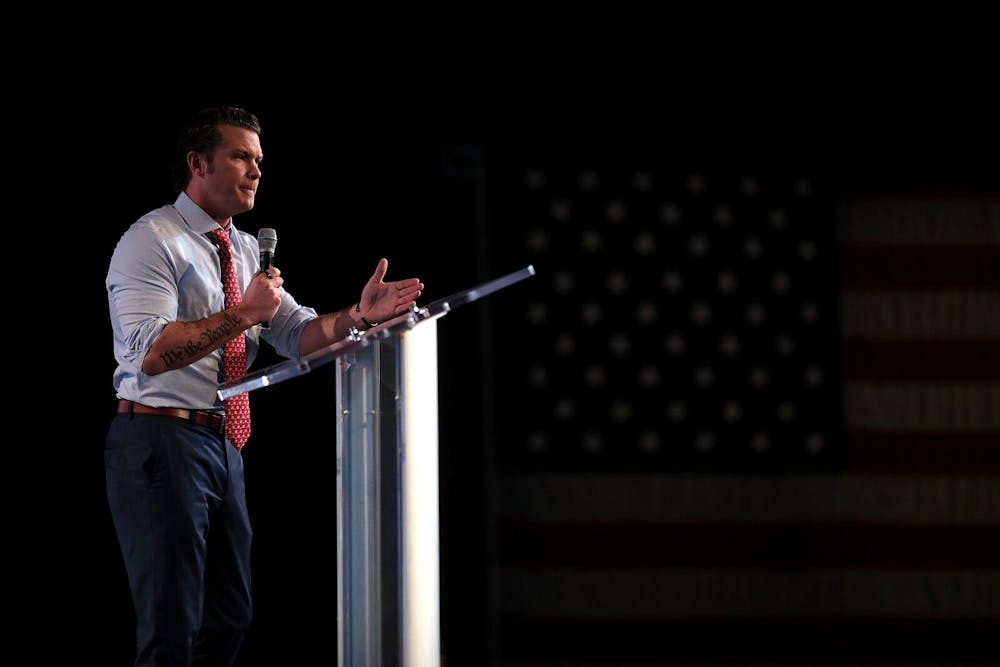 A man stands at a podium and speaks into a microphone.