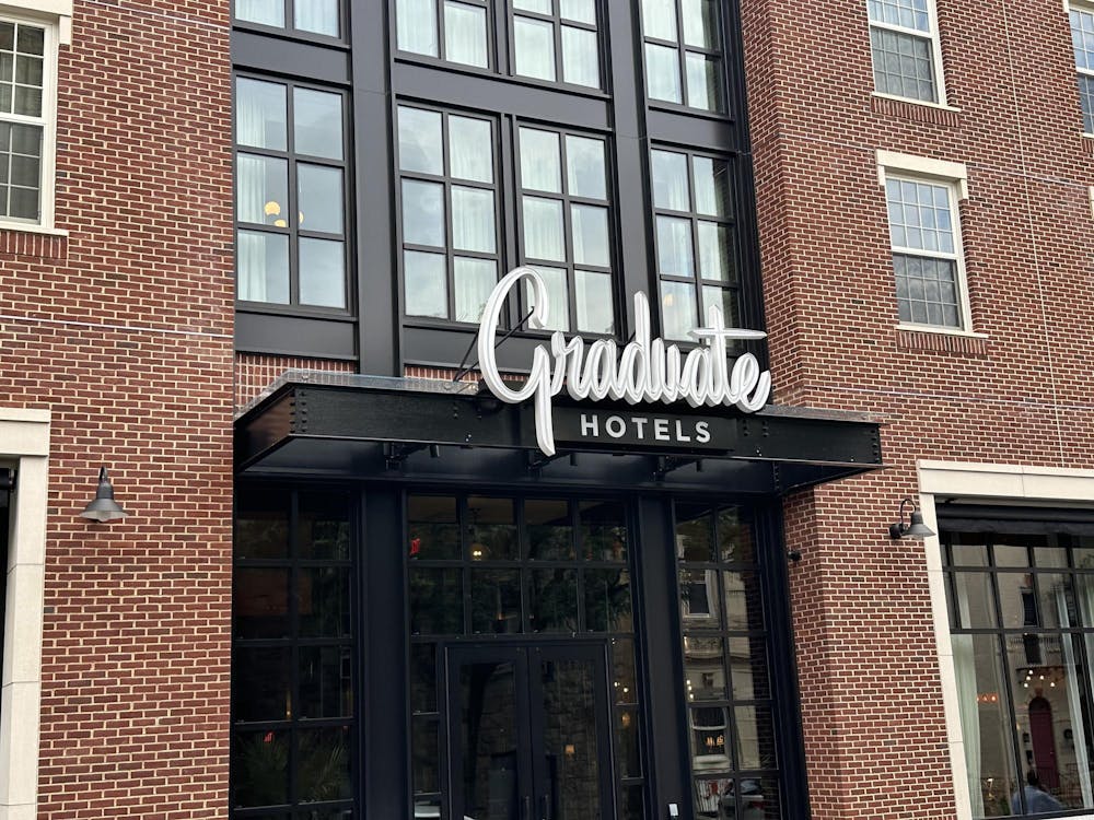 A brick building with black doors and windows, and a sign reading 'Graduate Hotels'