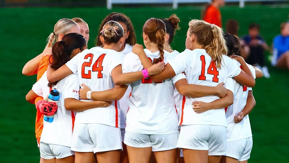Women huddling on field.
