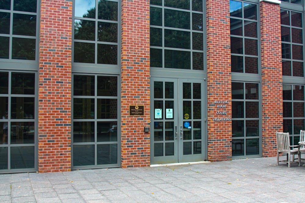 A red-brick courthouse with grey lettering reading “meeting room,” “court,” and “violations.”