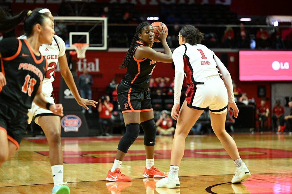 Tiger women’s basketball player protects ball against a Rutgers defender