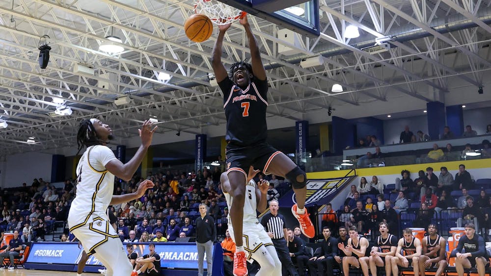 A man dunking a basketball during a basketball game while wearing orange and black 
