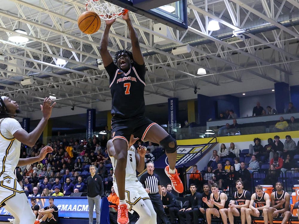 A man dunking a basketball during a basketball game while wearing orange and black