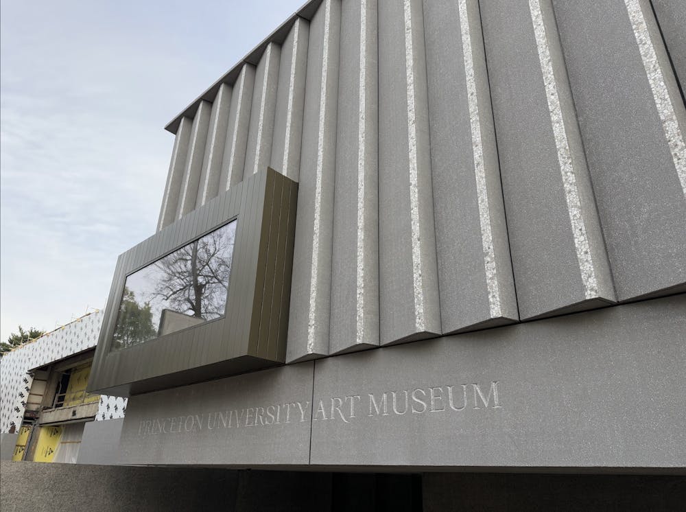 A gray concrete wall with a window and the words “Princeton University Art Museum” etched into it.