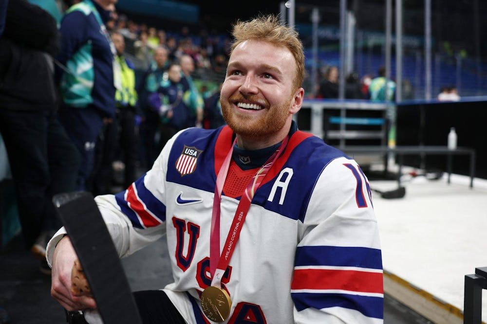 A sled hockey player in a red, white, and blue Team USA jersey smiles while wearing a Milano Cortina 2026 Paralympic medal