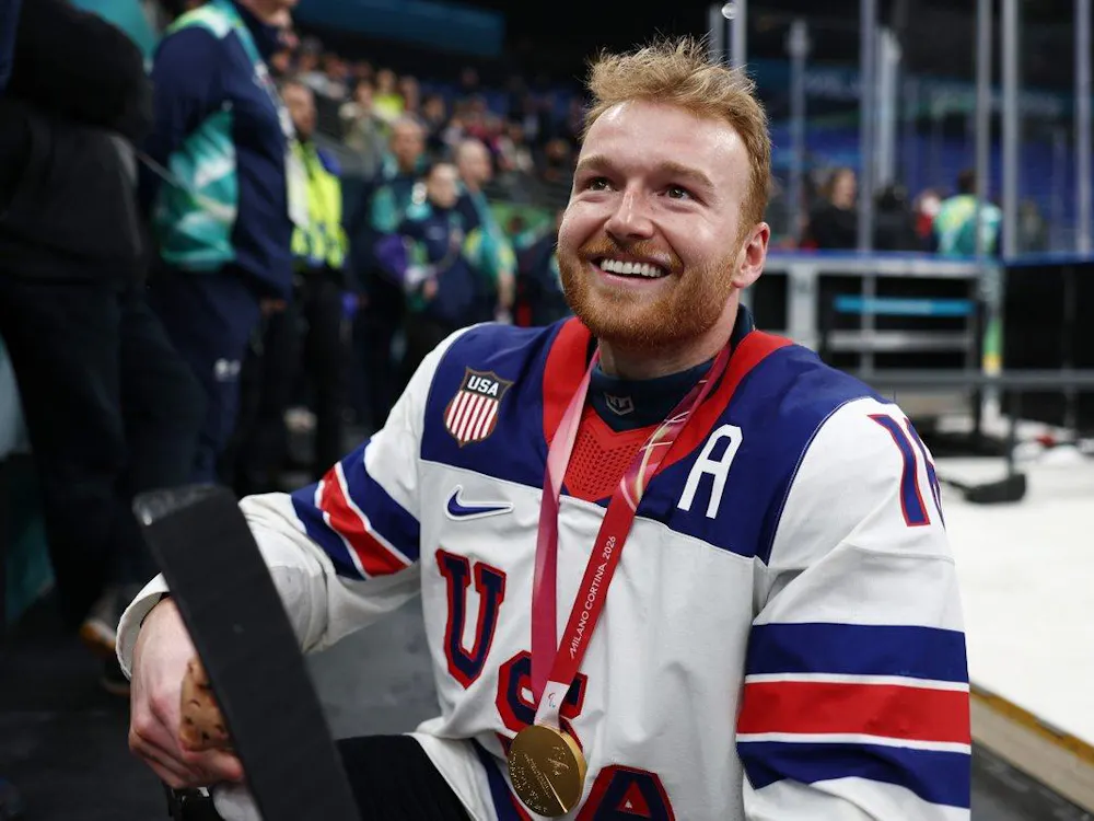 A sled hockey player in a red, white, and blue Team USA jersey smiles while wearing a Milano Cortina 2026 Paralympic medal