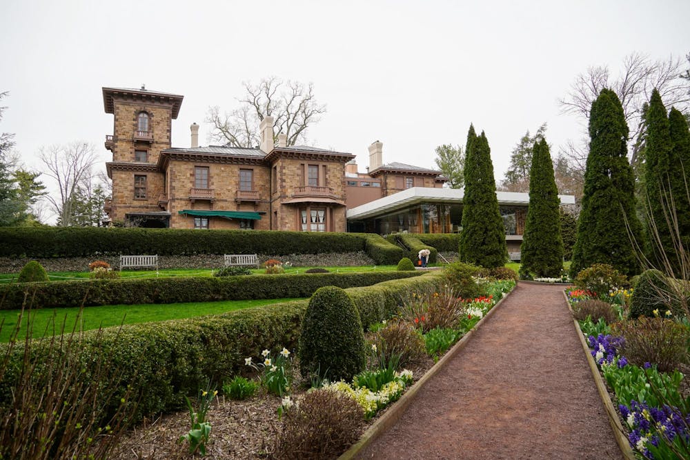 A mansion can be seen behind the garden. 