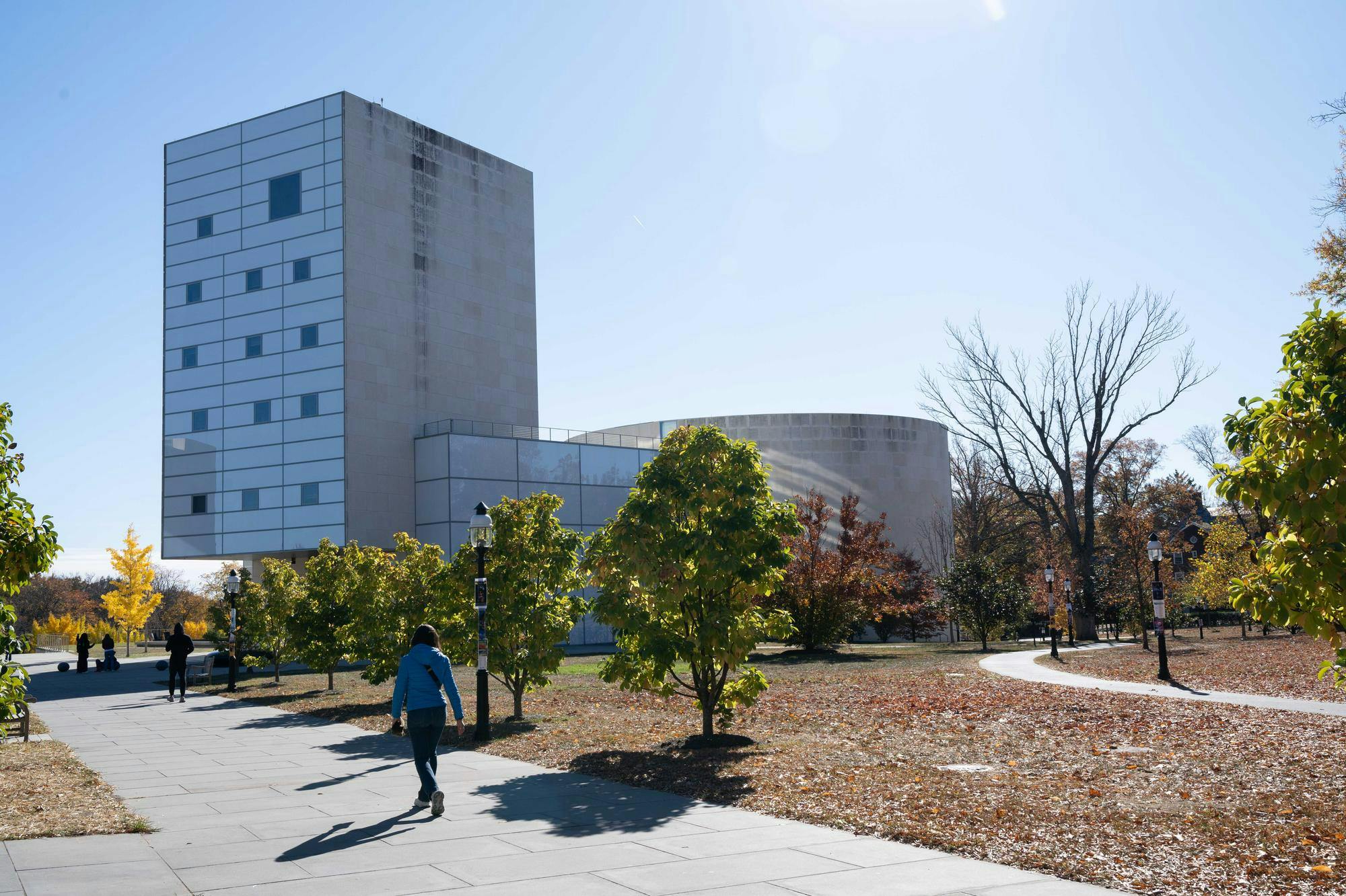 A large gray building stands out among the scenery of a sunny fall day