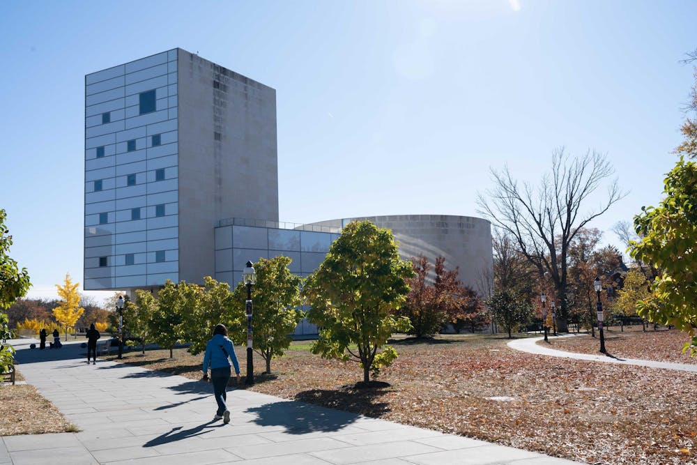 A large gray building stands out among the scenery of a sunny fall day