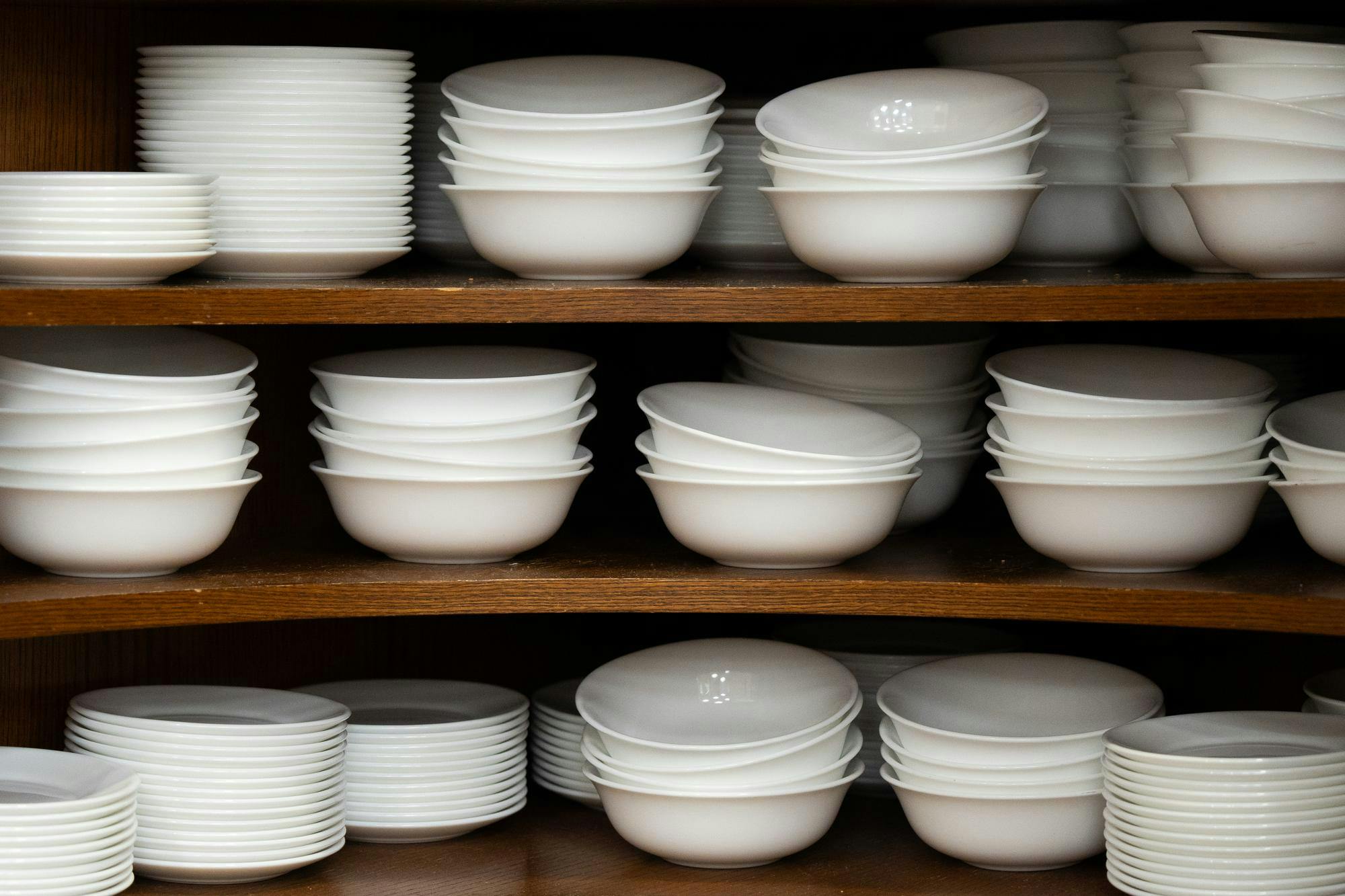 A shelve of unevenly laid bowls and plates.