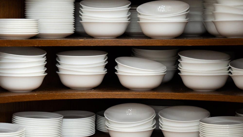 A shelve of unevenly laid bowls and plates.