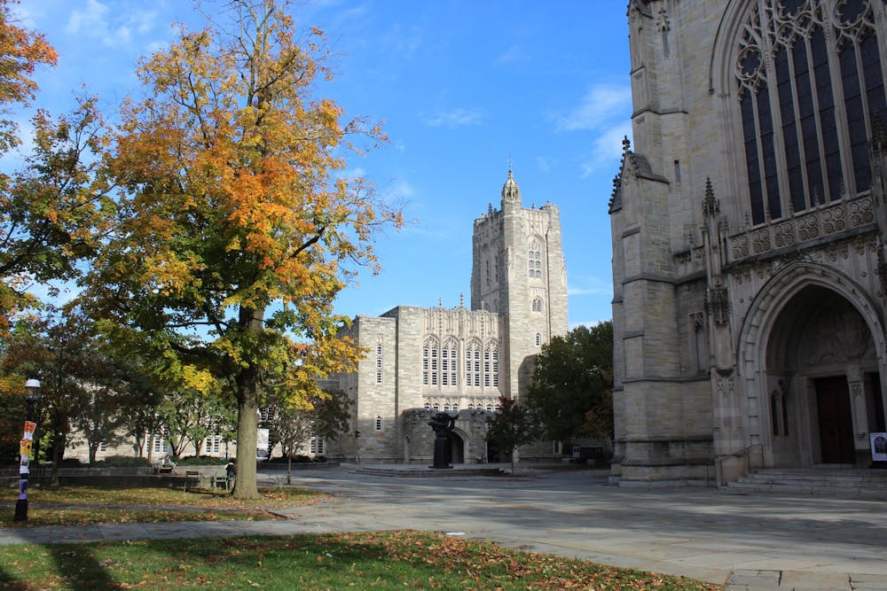 Two gothic buildings loom in the shot on a sunny day.