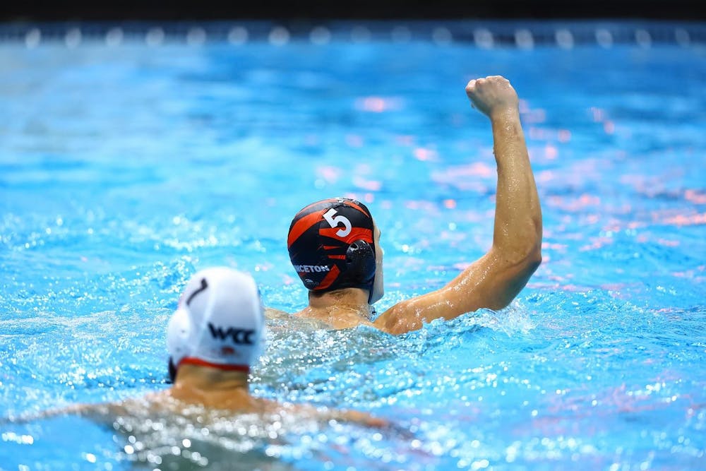 Two people in swimming caps in a pool.