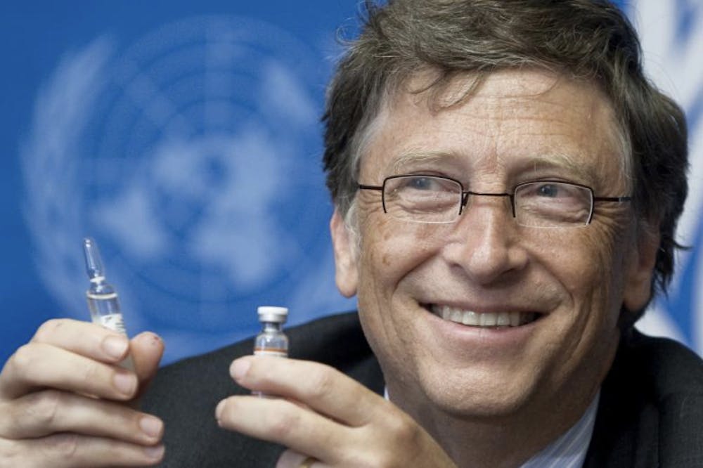 A man with classes holds a vaccine bottle up the camera